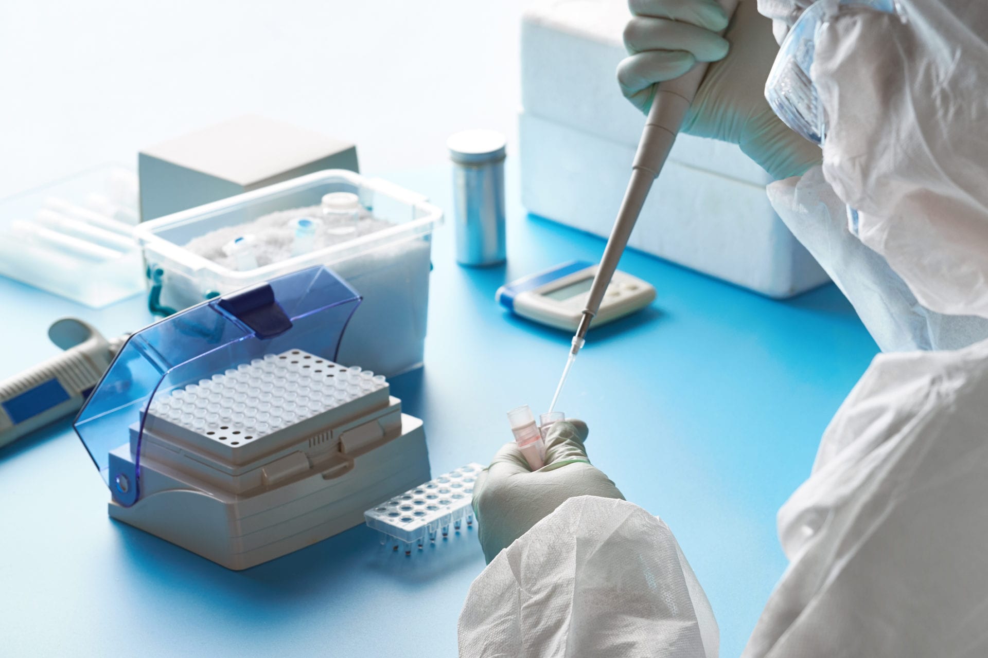 SARS-COV-2 pcr diagnostics kit. Epidemiologist in protective suit, mask and glasses works with patient swabs to detect specific region of 2019-nCoV virus causing Covid-19 viral pneumonia. Walk-In Clinic